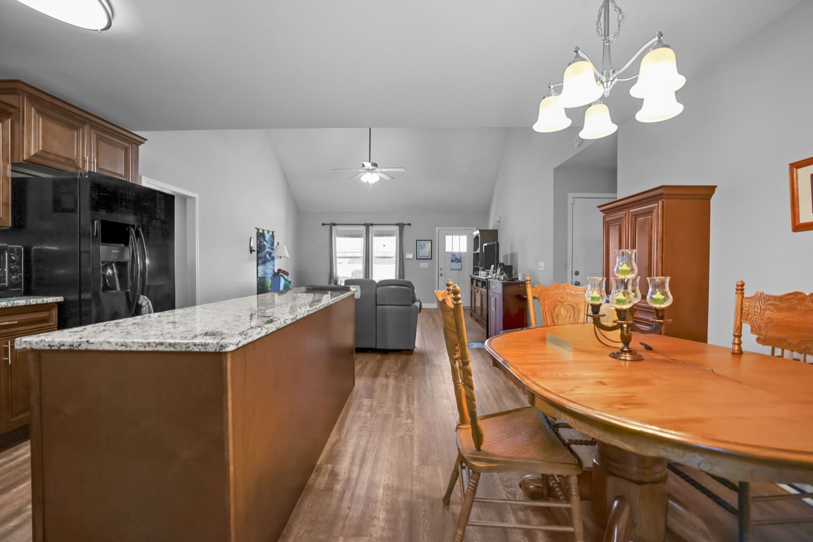 Open kitchen with granite island flowing into the dining and living areas of a Shelbyville TN listing